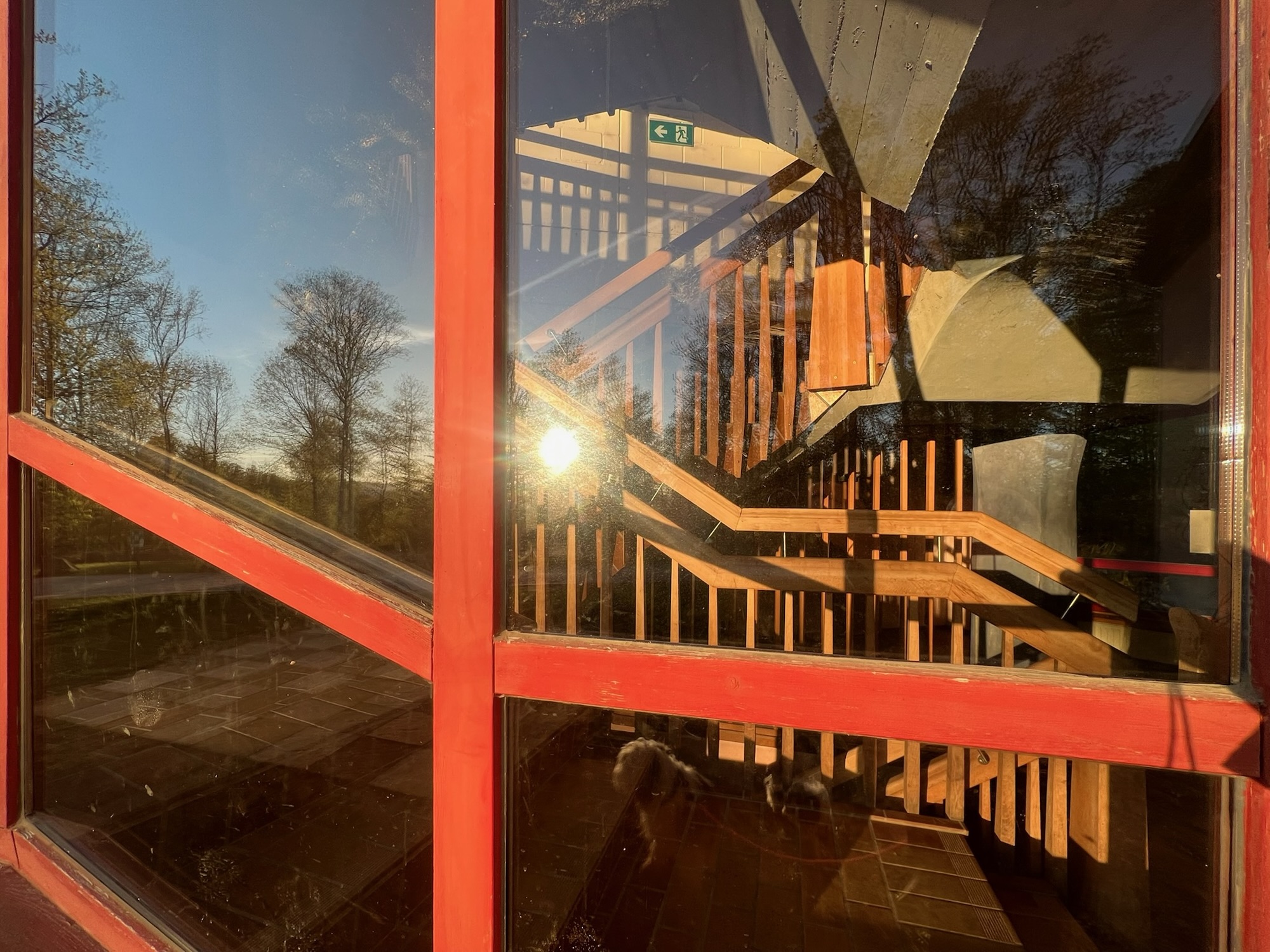 Spiegelung in Schulfenster, mit Treppe dahinter.