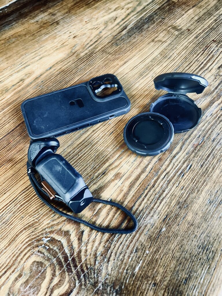 Eine Handyhülle vom Typ PolarPro LiteChaserPro für ein iPhone 13 Pro, mit danebenliegend Griff, Bluetooth Shutter, Polfilter und Deckel und Hülle für den Filter.