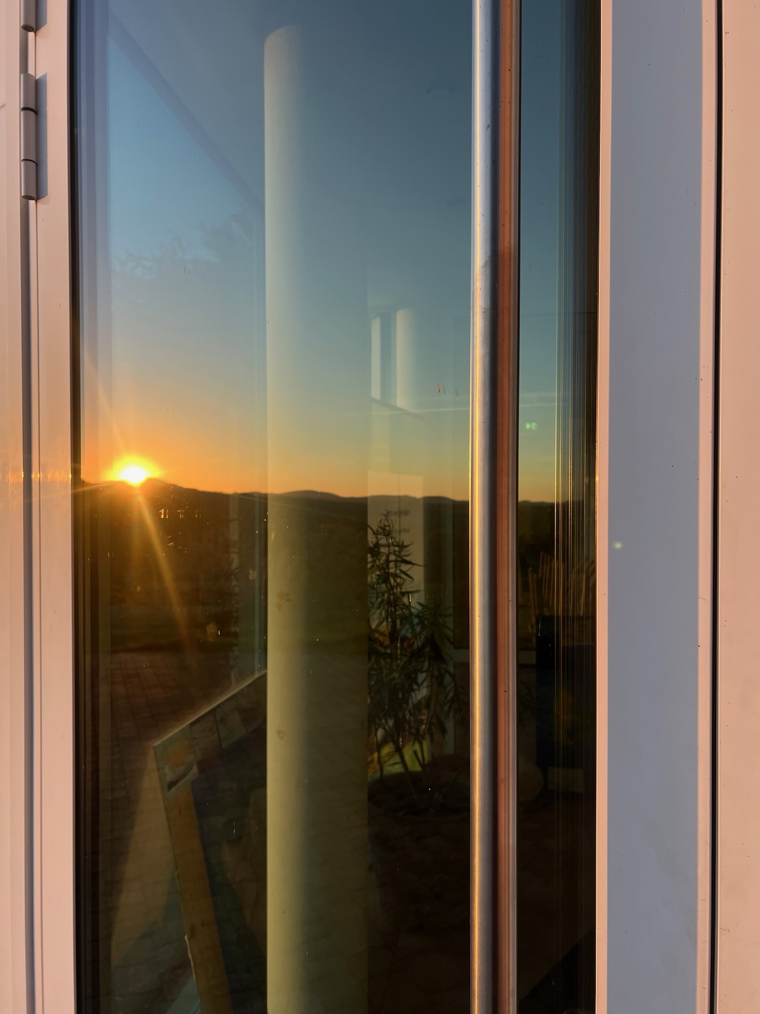 Sonnenaufgang in Mensa-Türscheibe gespiegelt