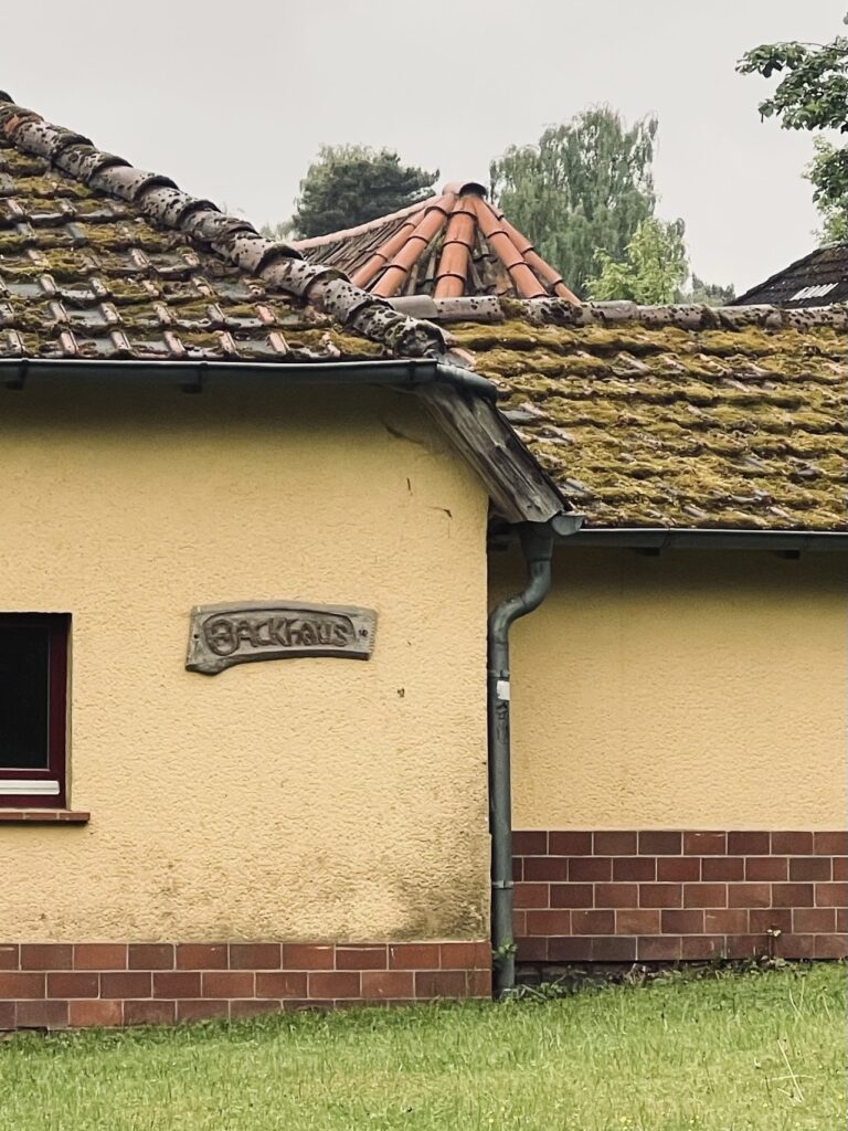 Das Backhaus mit Schuppenspitze darüber sichtbar.