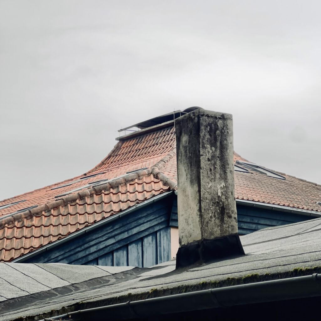 Schornstein und Dach vor Schuldach