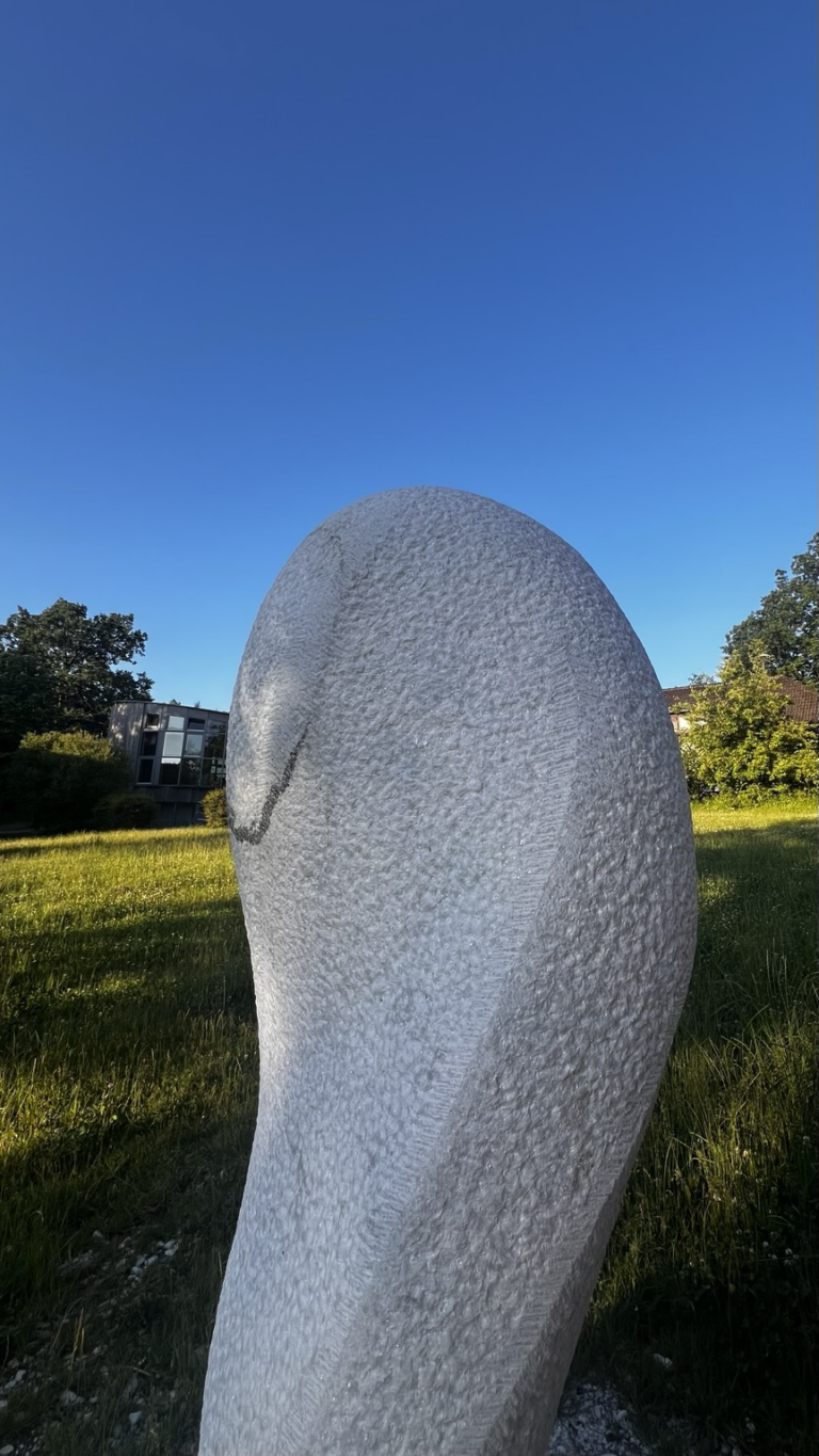 Statue Verwandlung auf Wiese neben Wagenschuppen